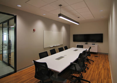 Modern conference room with a long white table and ergonomic chairs, ideal for Kazar's Electric project meetings.