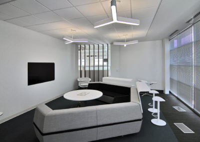 Modern seating area with sectional sofa, highlighting Kazar's Electric's electrical installation projects.