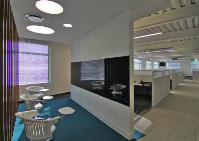Modern office space with lounge seating and glass partitions for Kazar’s Electric, Inc.'s project portfolio.