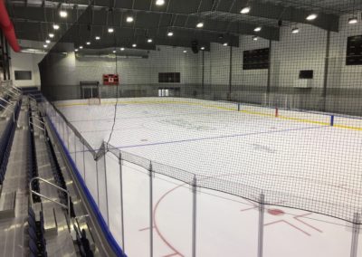 Hockey ice rink with calm atmosphere, goal posts, seating, and dasher boards, highlighting Kazar’s Electric's project focus.