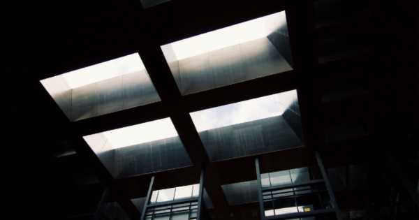 Industrial lighting installation with skylights allowing natural light, enhancing energy efficiency and visibility for commercial spaces.