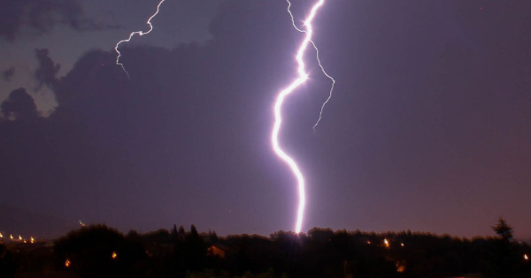 Lightning striking during a storm, illustrating the potential cause of power surges that can damage home appliances.