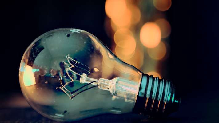 Light bulb with filament, symbolizing industrial lighting solutions and electrical services.