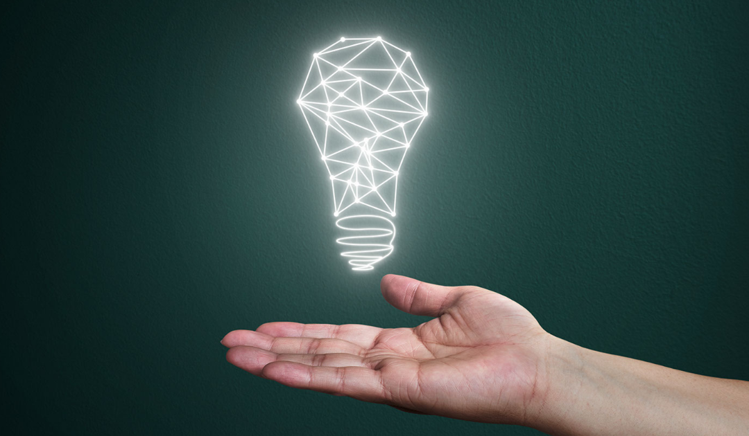 Hand holding an illuminated light bulb graphic, symbolizing innovative lighting solutions for outdoor commercial spaces and enhancing safety in parking areas.