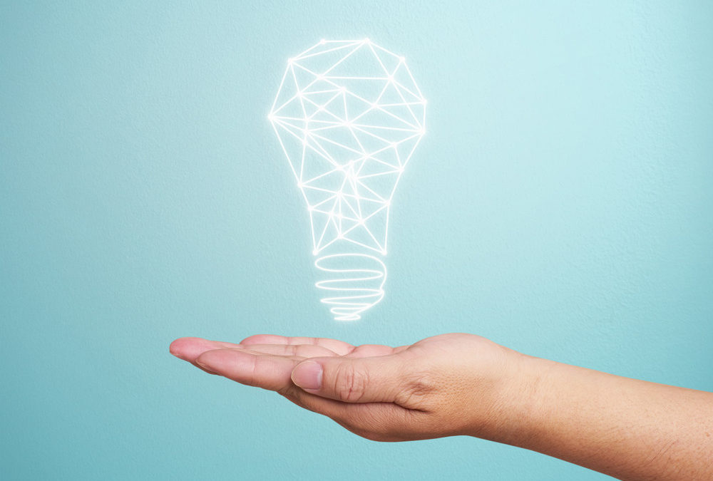 Hand holding a light bulb illustration, symbolizing innovative industrial lighting solutions for enhanced safety and productivity in industrial facilities.