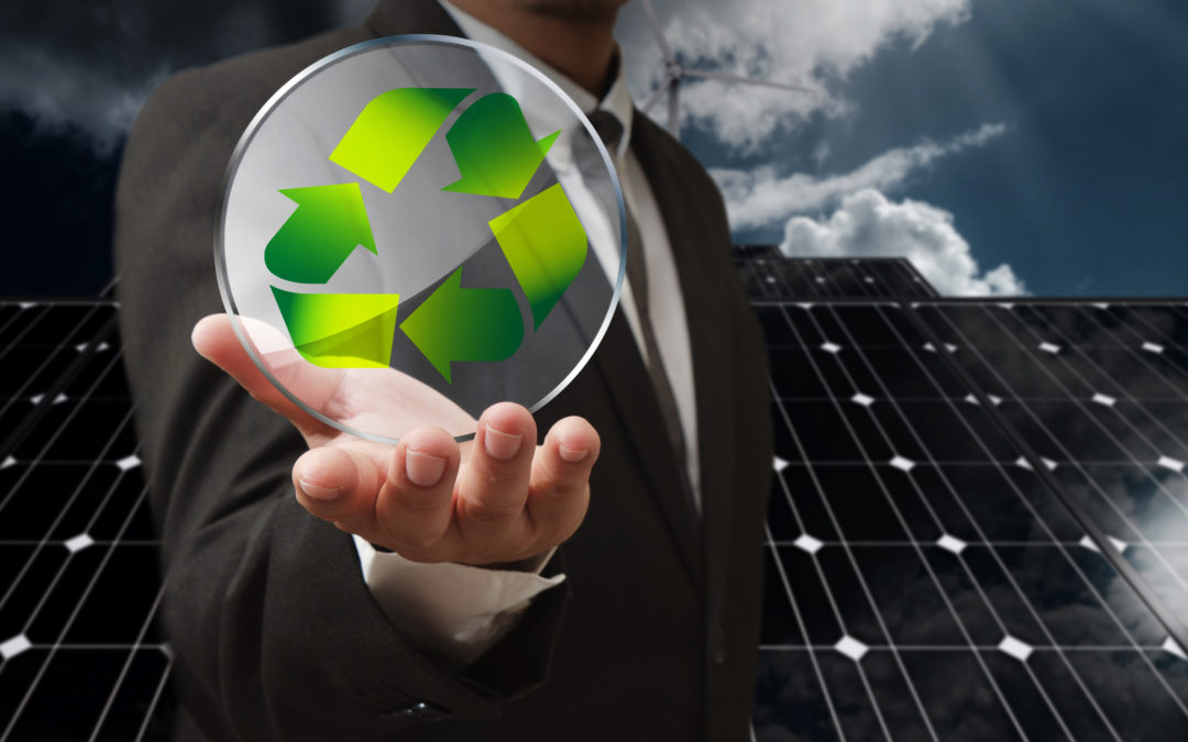 Businessman holding a transparent circular recycling symbol in front of solar panels, emphasizing energy efficiency and sustainability.