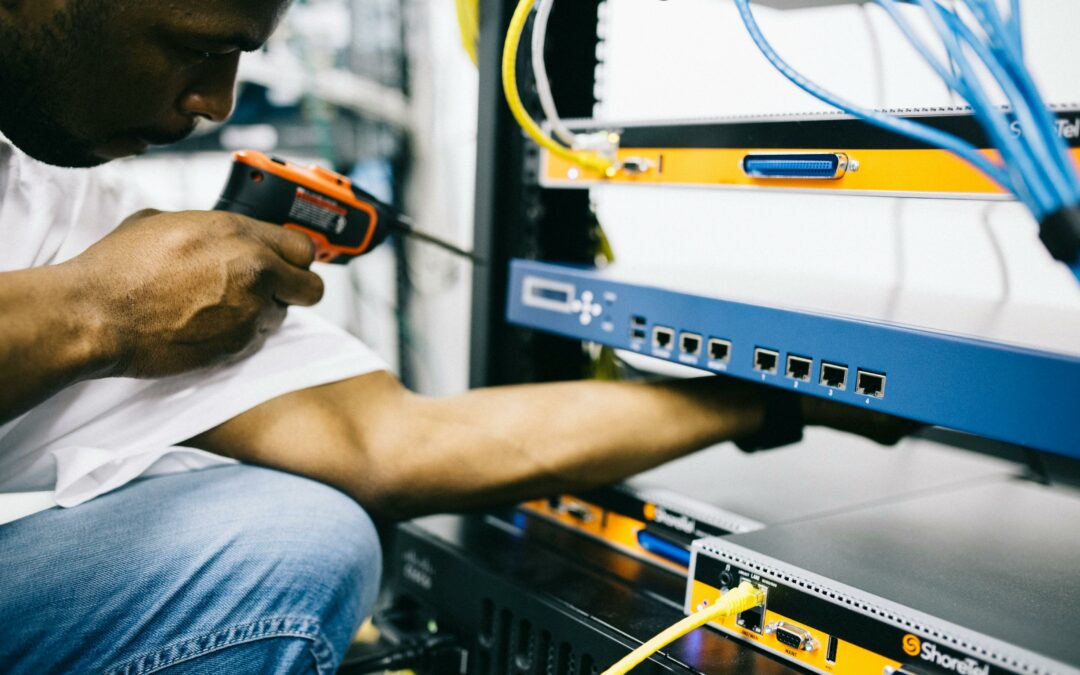 Technician working on server rack, using tools for CATV wiring upgrades by Kazar's Electric.
