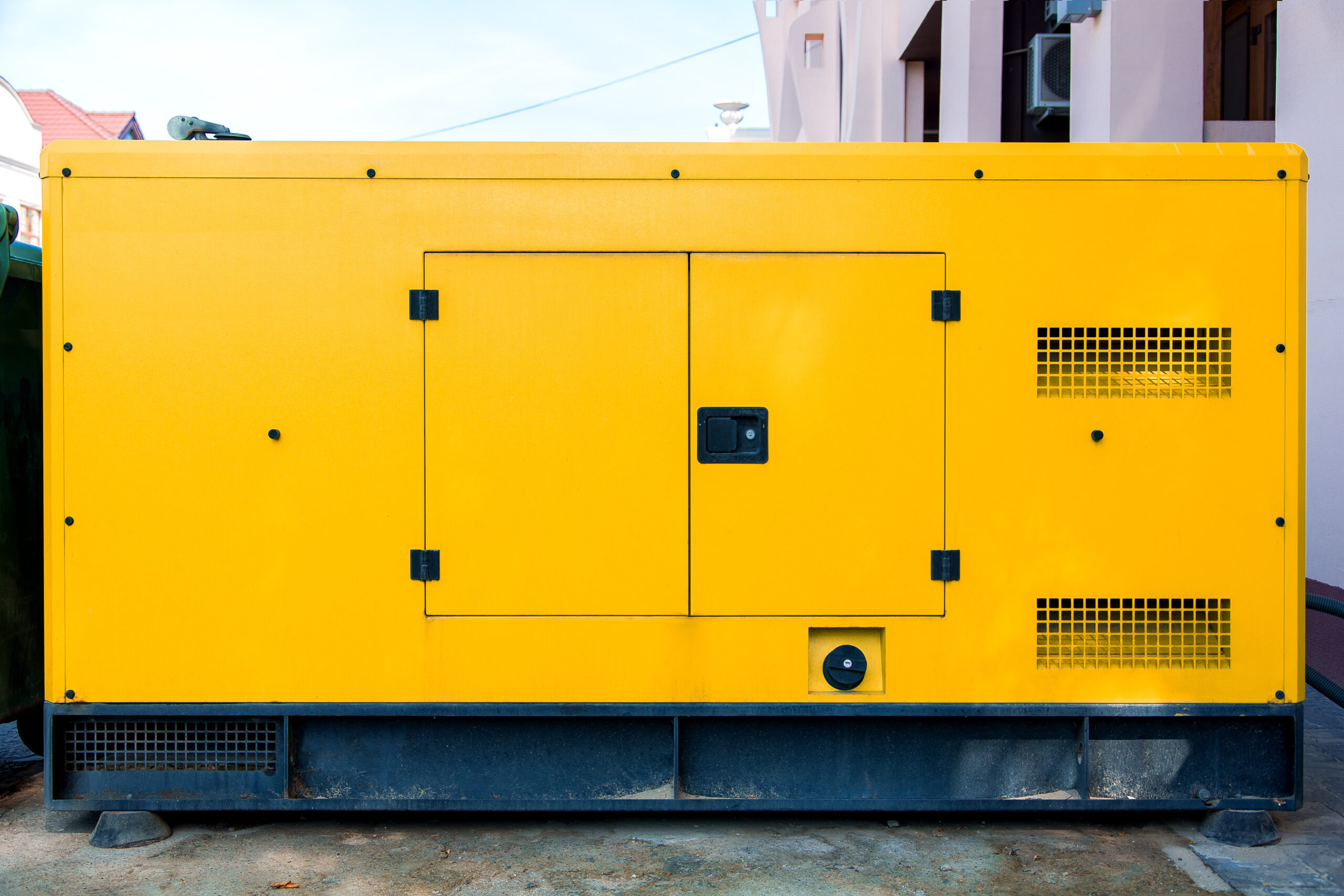 Yellow generator unit positioned outdoors, illustrating the importance of generator backup for businesses during power outages.