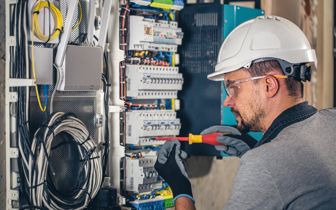 Electrician working on a control panel, highlighting Kazar's Electric's professionalism and safety in electrical services.