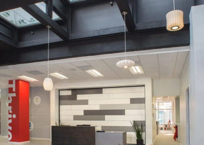 Welcoming reception area of Kazar’s Electric with modern desk, large windows, and 'Thrive' wall art.